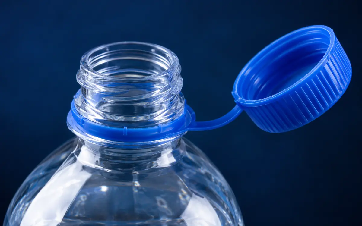 Attached cap on a beverage bottle